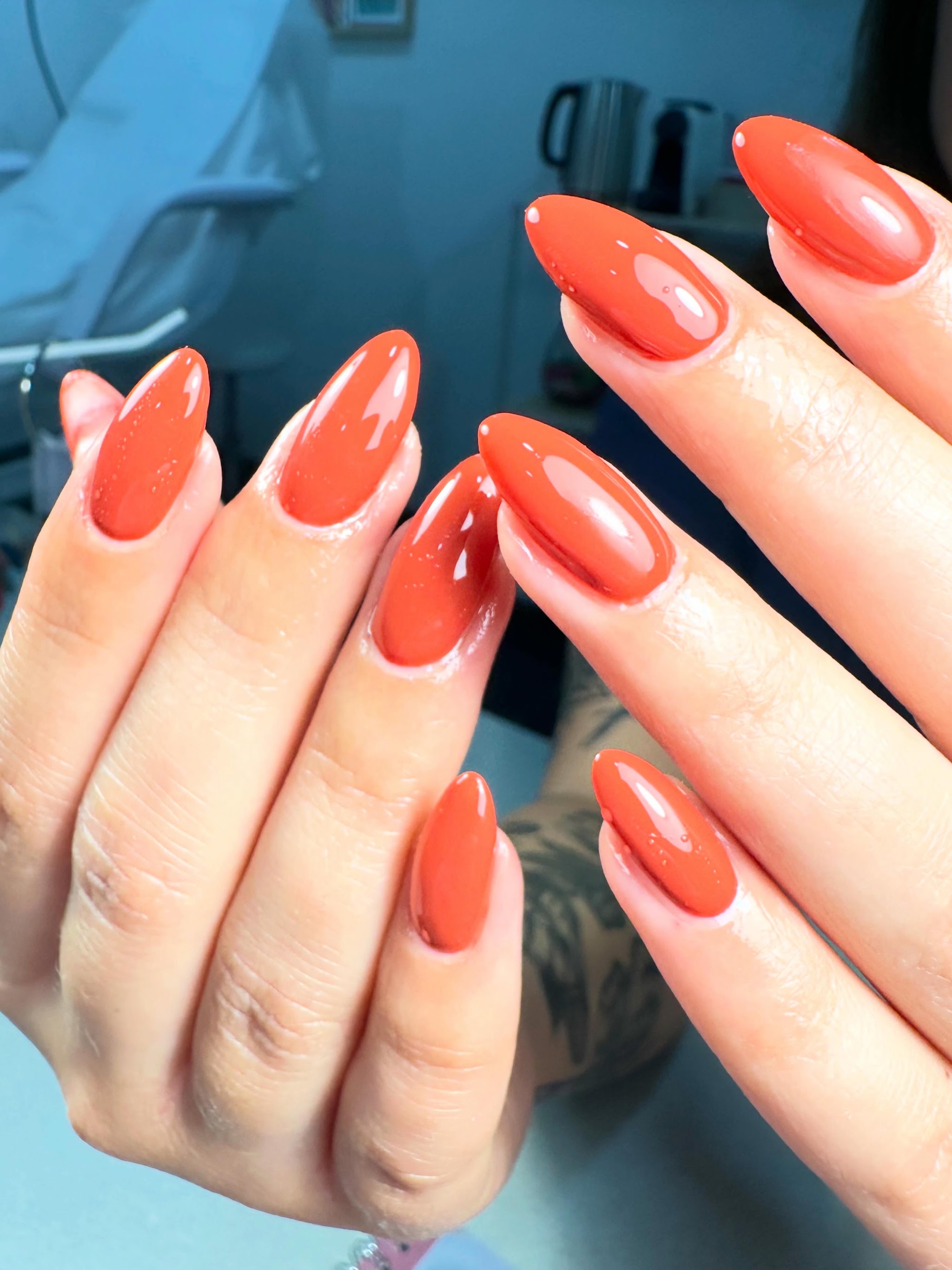 Glanzende oranje nagels, afgewerkt bij Nausika beauty & nails studio